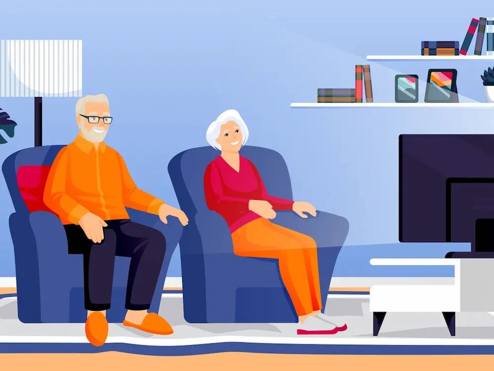 An elderly couple watching TV