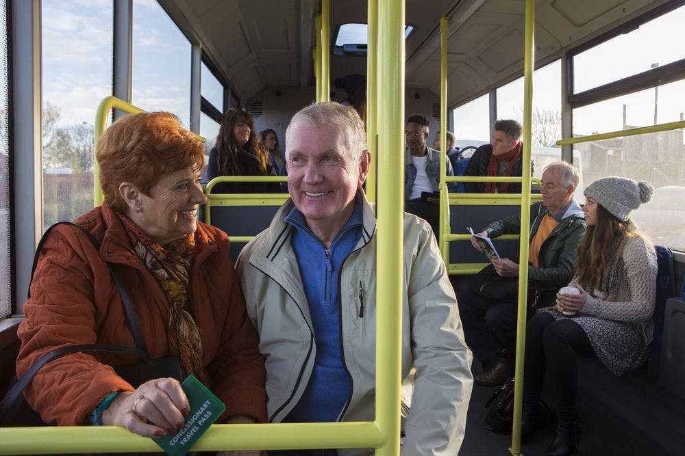 Elderly couple sitting near the front of a bus