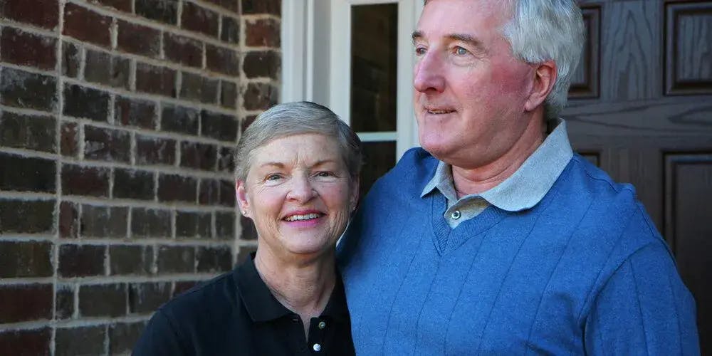 Elderly couple stood outside their home
