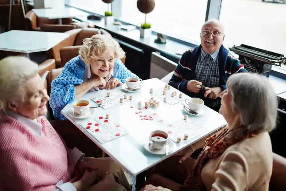 Four older adults playing board games