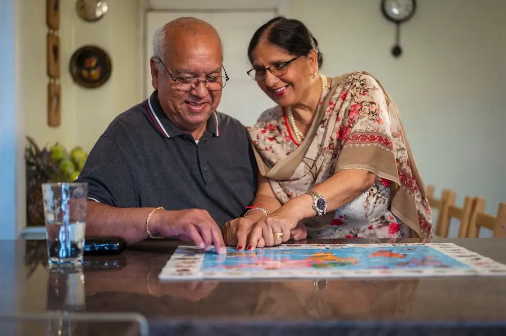 Older man and woman doing a jigsaw together
