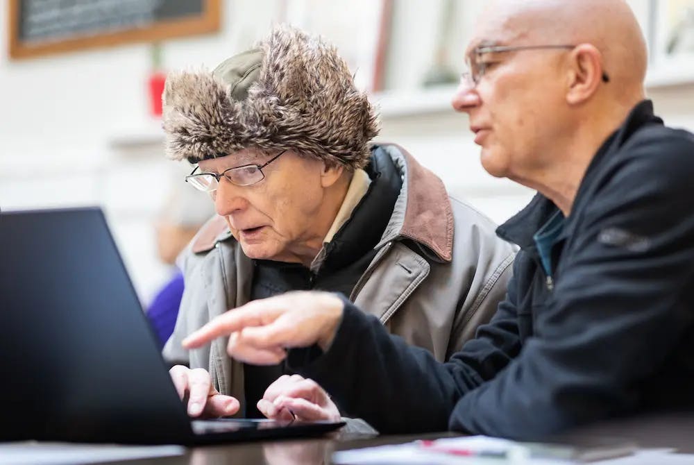 Pair of older men using a laptop together