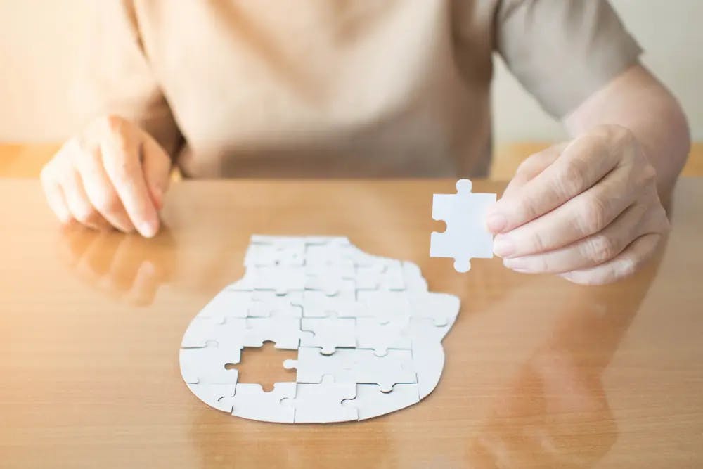 Person filling in a head shaped jigsaw