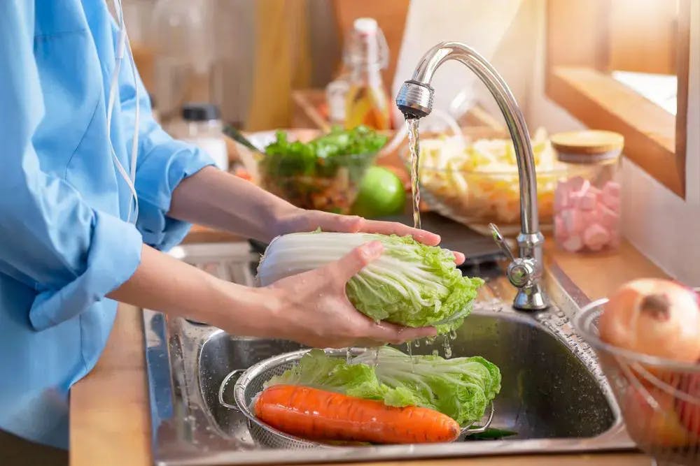 Person washing vegetables