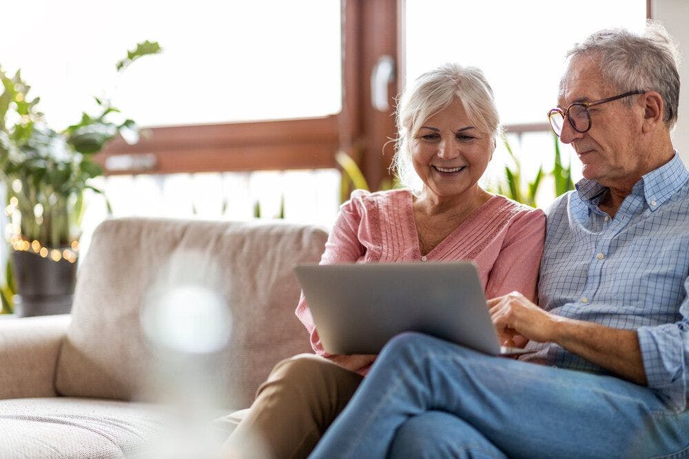 An elderly couple looking at the laptop