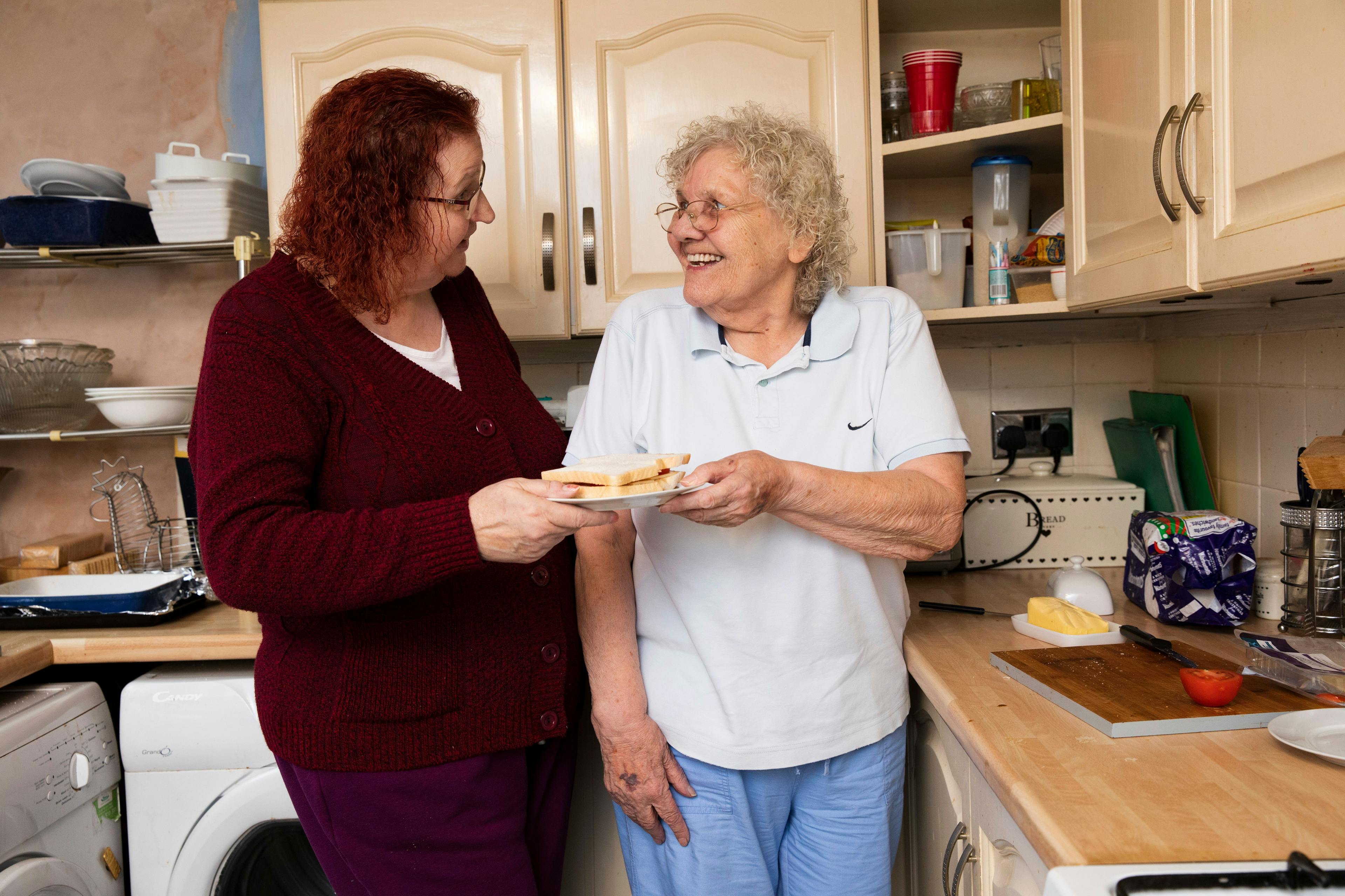 Two older women making food together
